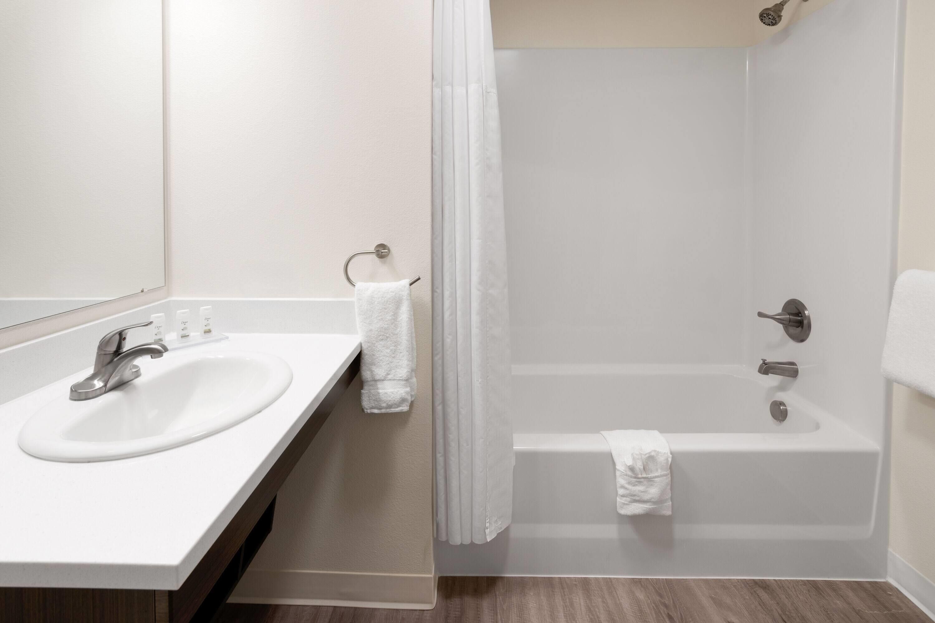A bathroom with a white sink, a bathtub, and a shower curtain.