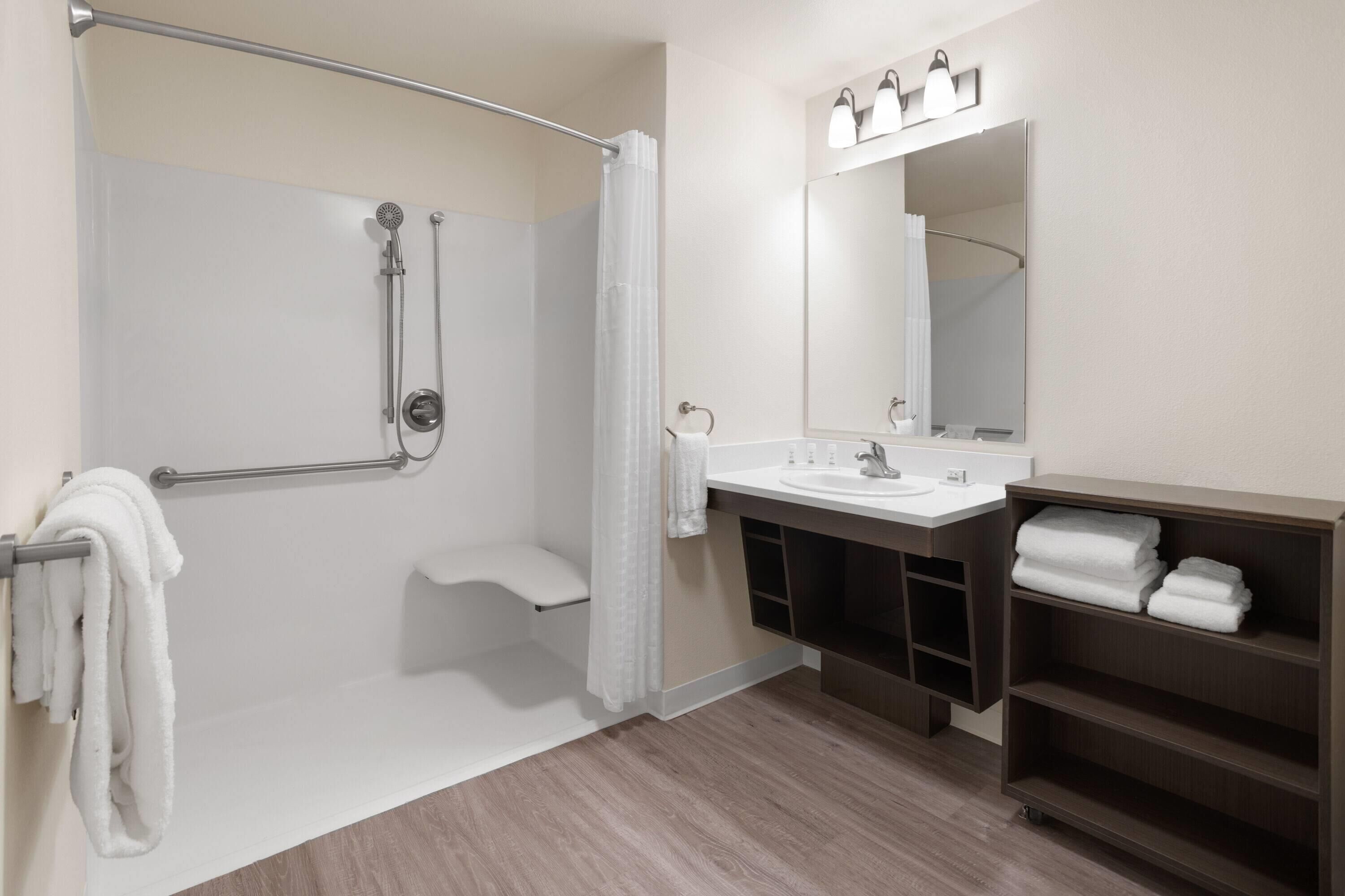 A modern bathroom with a shower, toilet, sink, and vanity.