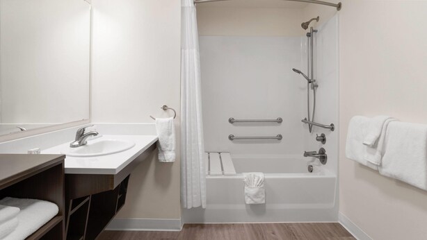 Une salle de bain moderne avec un lavabo, un miroir et une douche.