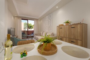 A modern living room with a sofa, dining table, and a cabinet.