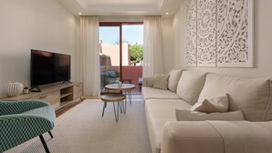 A living room with a sofa, TV, and decorative wall panel.