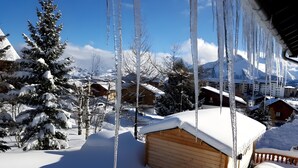 A snow-covered landscape with wooden cabins and icicles hanging from the roof. - Chalet 'Ground Floor 110 m² – Very Close to the Slopes' with Mountain View, Private Terrace & Wi-Fi (Fontcouverte-la-Toussuire)