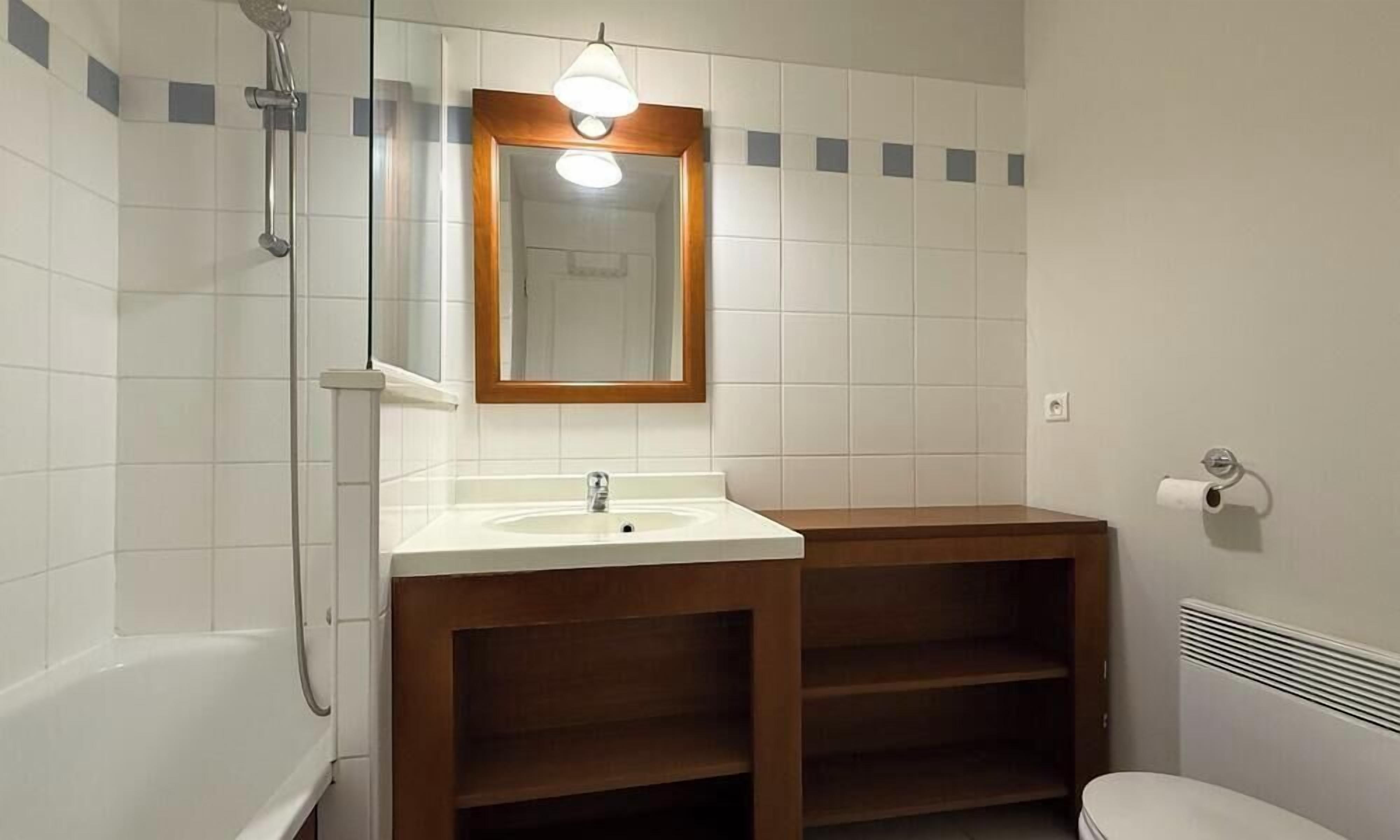 Une salle de bain avec une douche, un lavabo, un miroir et des toilettes.