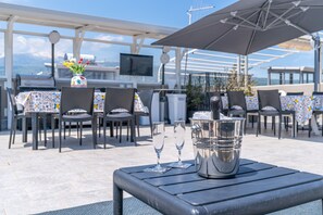 An outdoor dining area with tables, chairs, and a large umbrella.