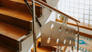 Una escalera moderna con escalones de madera y barandillas metálicas.