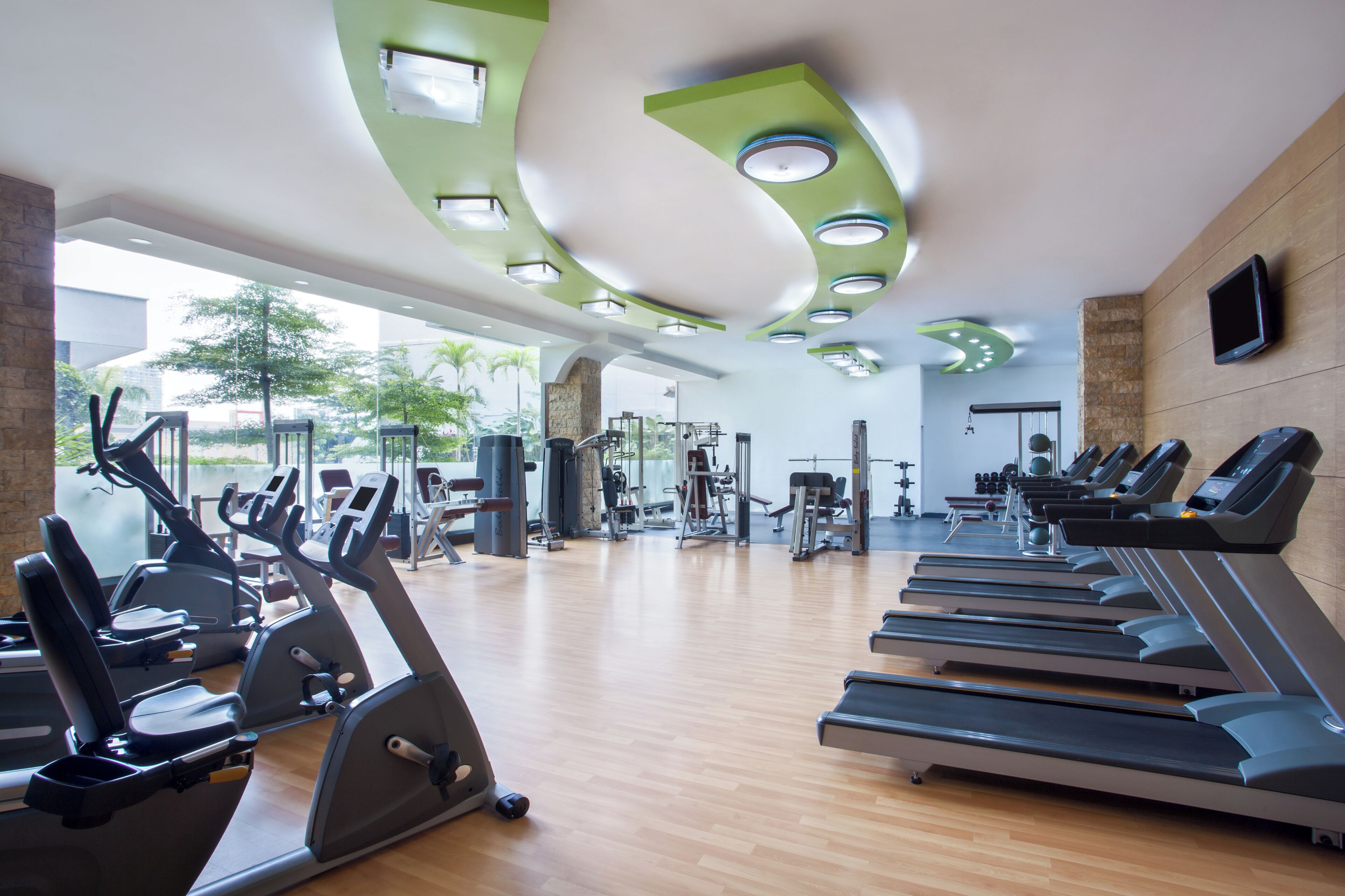 A gym with treadmills, elliptical machines, and weight equipment.