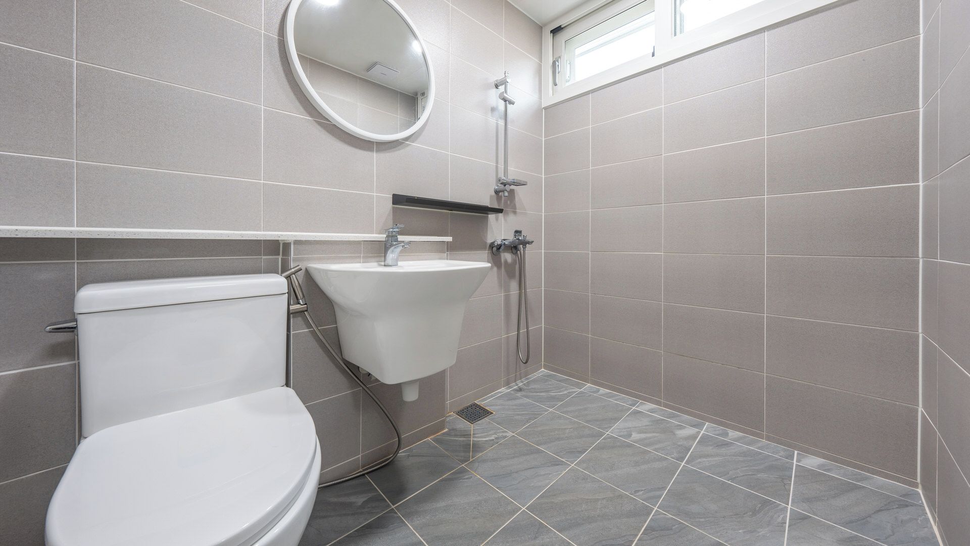 A bathroom with a toilet, sink, and shower.