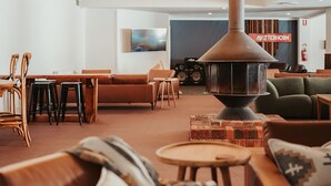 Un espacio lounge acogedor con una estufa de leña central, asientos cómodos y un cartel visible que dice 'Mutterhorn'.