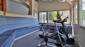 A gym with a blue bench, a spinning bike, and a treadmill. - The Powder Pad Studio - Perfect for Two - On Shuttle Route w/ Amenities A4A (Killington)
