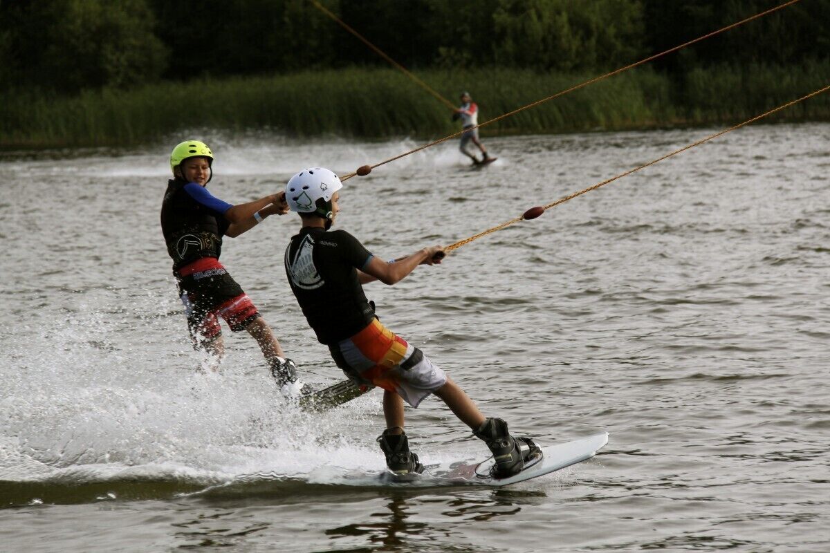 A person wakeboarding on a body of water with a rope connected to a boat.