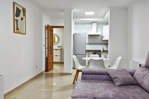 Uma sala de estar moderna com um sofá e uma área de jantar com cadeiras e mesa.