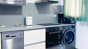Een praktische keuken met vaatwasser, magnetron, oven en wasmachine.