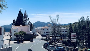 Une vue de rue avec des bâtiments, des voitures et un ciel bleu dégagé.