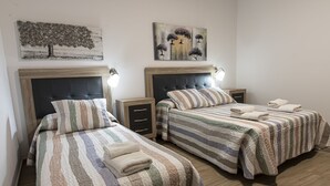 Une chambre d’hôtel avec deux lits, chacun doté d’une tête de lit, de tables de chevet et de lampes.