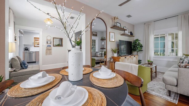 Un salon moderne avec un coin repas, agrémenté d  ’un grand miroir, d’un téléviseur et d’un espace salon confortable.