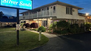 A two-story building with a balcony, a "No Parking Zone" sign, and a neon sign reading "Silver Sands". - Silver Sands Hotel & Resort (Mears)