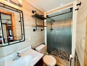 Huisje, patio, uitzicht op meer | Badkamer | Een bad/douchecombinatie, een haardroger, handdoeken, zeep