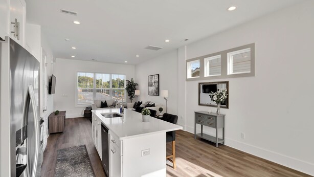 A modern kitchen with a central island, a dining area, and a small seating space. - Stylish Two Story Close to South End and Uptown (Charlotte)