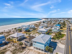 Zona residencial costera con propiedades frente al mar, una avenida principal y una playa.