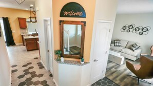 A modern home interior with a kitchen, living area, and a hallway with a 'Welcome' sign.