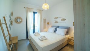Une chambre bien rangée, avec un lit, des tables de chevet, un miroir et un luminaire suspendu.