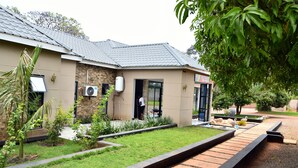 A modern house with a tiled roof, a front door, and a small garden with a pathway. - Alexandrina's Corner Bed and Breakfast (Chipata)