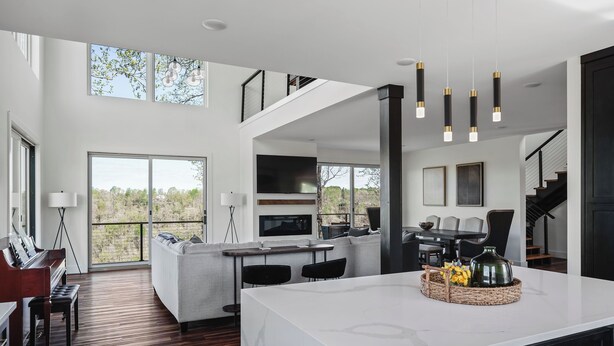A modern kitchen with a large island, built-in appliances, and a dining area with a piano. - The Panorama Overlooking Center Hill Lake (Sparta)