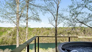 A hot tub on a wooden deck with a view of a lake and forest. - The Panorama Overlooking Center Hill Lake (Sparta)