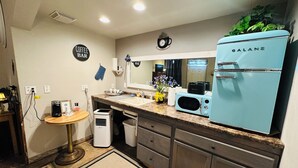 A compact kitchen with a coffee bar sign, a microwave, a toaster, and a blue refrigerator. - Salmon River Inn (Salmon)