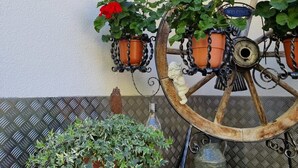 A decorative wheel with potted plants, a welcome sign, and a metal bucket on a textured wall. - Vacation home Vesul by Interhome (Kappl)