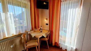 A cozy dining area with a table and chairs, a bottle of wine, and curtains. - Vacation home Vesul by Interhome (Kappl)