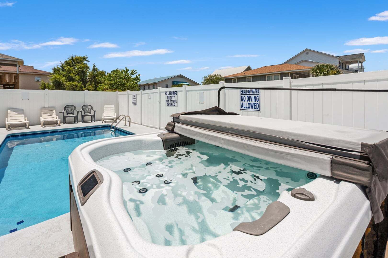 Une piscine avec un jacuzzi et des chaises longues.