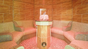 A spa room with a central pillar, two cushioned seating areas, and a tiled floor. - Apartment Edith by Interhome (Imst)