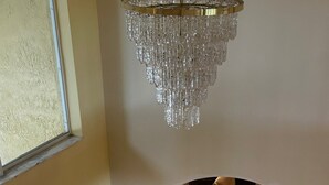 A dining area with a chandelier, a round table, and six chairs. - Wellington Hideaway Villa a spacious 5-bedroom house close to the Polo Club (Wellington)
