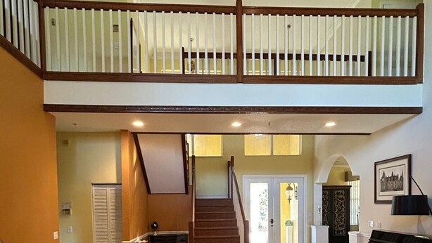 A spacious living area with a grand piano, a staircase leading to an upper level, and a decorative table with chess pieces. - Wellington Hideaway Villa a spacious 5-bedroom house close to the Polo Club (Wellington)