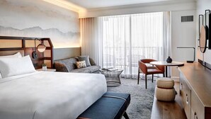 A hotel room with a large bed, a sofa, a dining table with chairs, a small coffee table, and a TV. - Marriott Desert Spring Villas- available march 2-9 only (palm desert)