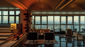 A spacious living area with a city view, modern furniture, and a fireplace.