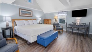 A bedroom with a large bed, a desk with two chairs, a television, and a window with curtains. - Summer Wind - Your Serene Cape Cod Getaway (South Yarmouth)
