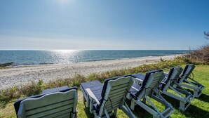 A beach with sun loungers and a view of the ocean.