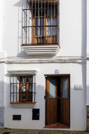 La Casa Del Risco features a charming two-story facade with a wooden door and a balcony above.