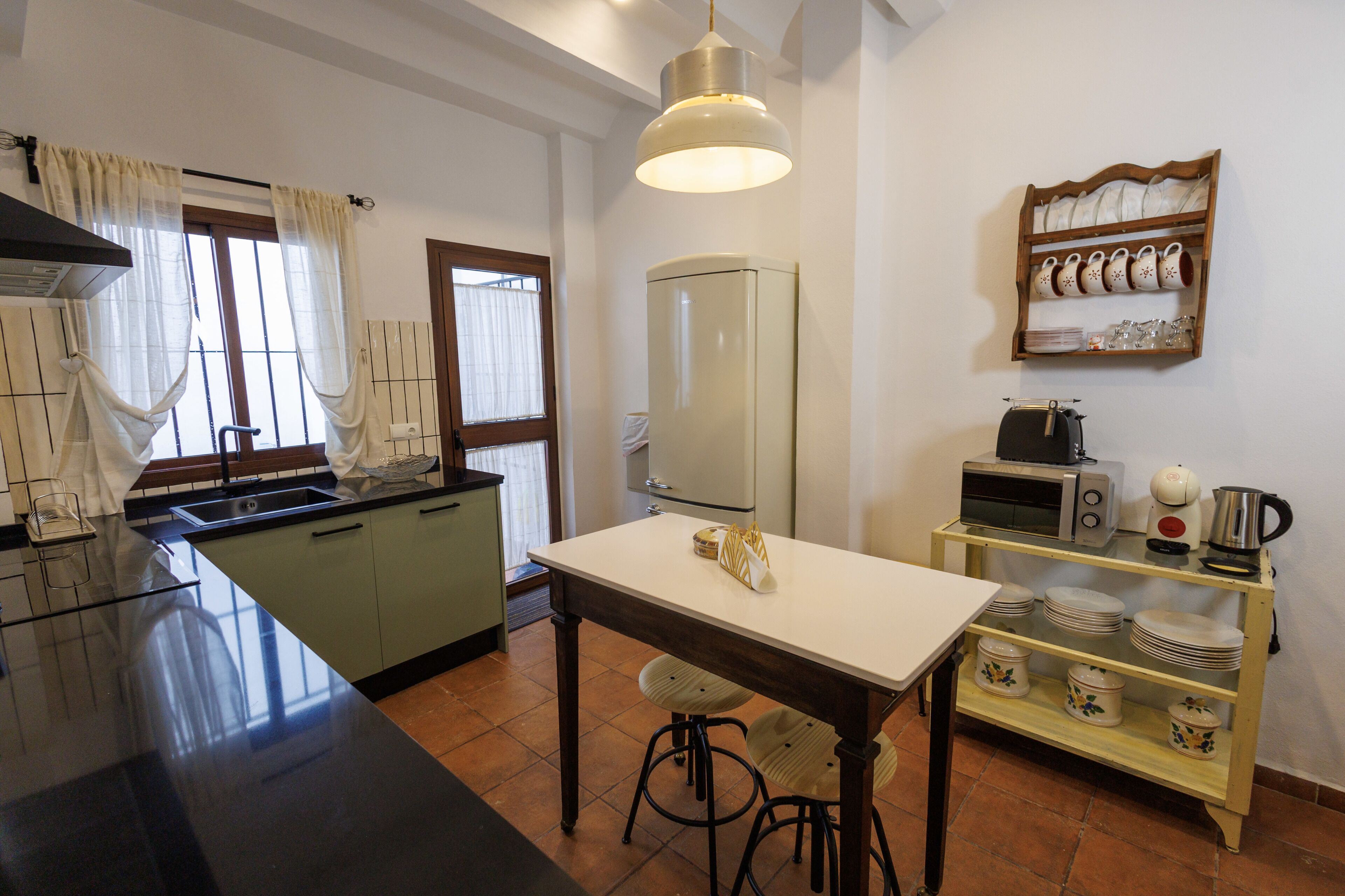 Una cocina con una isla central, una mesa de comedor y un horno empotrado.
