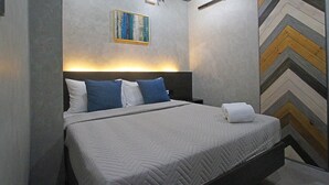 Un dormitorio moderno con cama, cabecera, un cuadro y pared con diseño de tablero de ajedrez.