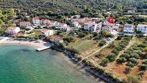 Vista aérea de un pueblo costero con casas, una playa y un muelle.