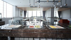 Montaje tipo bufé con diversas opciones de comida y un diseño de techo moderno.