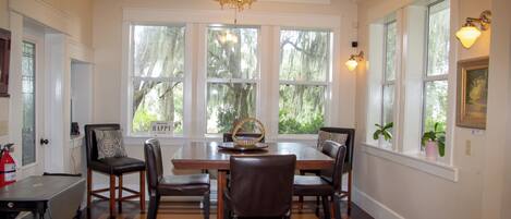 A dining area with a wooden table, six chairs, and a ceiling fan.
