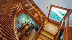 Una escalera de madera con vista a una habitación de abajo.