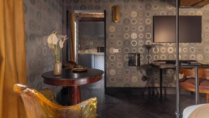 A room with patterned wallpaper, a round table with a vase of flowers, a television, and a wooden chair. - 2 Luxury Suites on the Same Floor - 1 min from Piazza Navona (Roma)