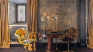 A room with a round table, two chairs, a vase with flowers, and patterned wallpaper. - 2 Luxury Suites on the Same Floor - 1 min from Piazza Navona (Roma)