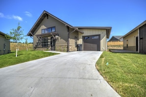 A residential building with a garage, a covered porch, and a well-maintained lawn. - Ski Run View Red Lodge (Red Lodge)