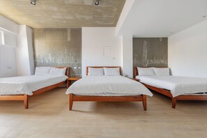 A modern hotel room with three wooden beds, white bedding, and a concrete ceiling. - Huyan Museum BnB - Concrete Design (Liuqiu)